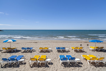 Mediterranean beach and sunbeds in Sitges,Catalonia,Spain.