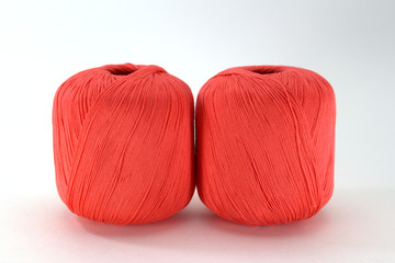 Bright pink tangles of natural cotton for needlework on a white background close-up