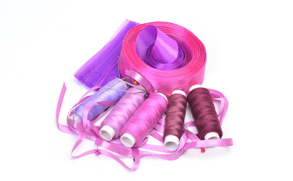 Bobbins, ribbons and pins on a white background