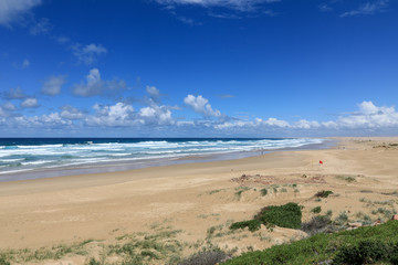 Cloudy blue sky over long sandy beach