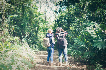 Fototapeta na wymiar Happy couple going on a hike together in a tropical forest