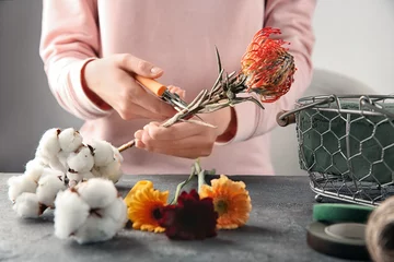Crédence de cuisine en verre imprimé Fleuriste Fleuriste femme faisant beau bouquet à table