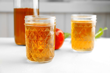 Jar with fresh apple juice on table