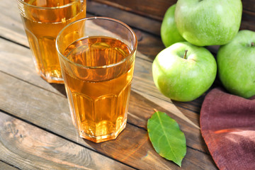 Two glasses of fresh apple juice on wooden table