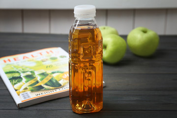 Bottle of fresh apple juice on wooden table