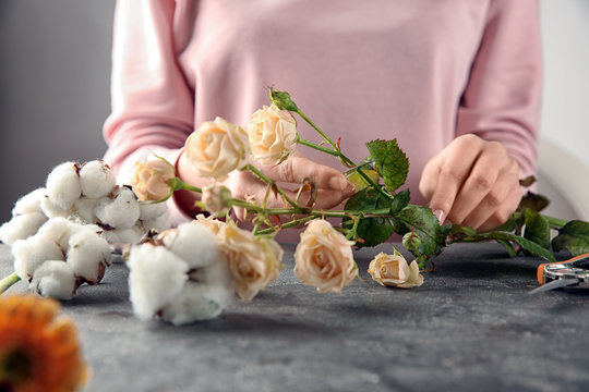 Female florist making beautiful bouquet at table