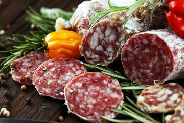 thinly sliced salami on a wooden texture on the background.