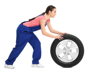 Obraz premium Female mechanic in uniform with car tire on white background