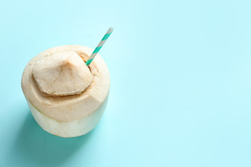 Fresh coconut drink in nut on color background