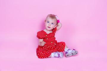 Fototapeta premium little girl is sitting on a pink background