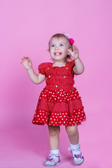 little girl laughing on a pink background in the studio