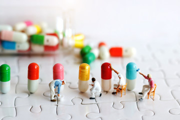 Miniature people: Workers  team brush painting Medicinal capsules. Healthcare, Medical  and...
