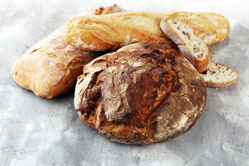 Different kinds of bread and bread rolls on board from above. Kitchen or bakery poster design