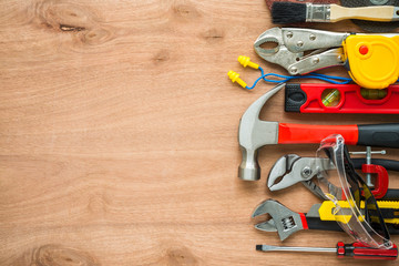 Flat lay, set of construction hardware tools building, repair, painting accessories on wooden board background