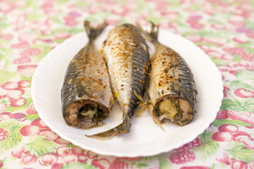 three baked fish on a white plate. Healthy food, seafood. Mackerel