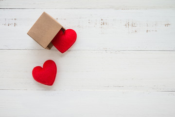 Two red hearts go out paper box on white wooden background - valentines day concept