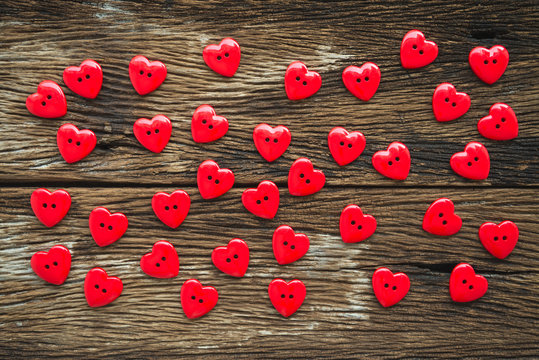 Flat lay of red buttons Valentines heart on old wooden, above view