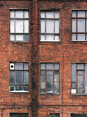 Obraz premium Facade of an old brick building in loft style. High Windows and textural materials.