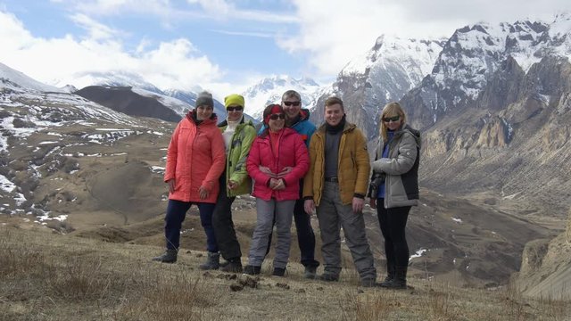 Group of tourists posing in front of a camera in the mountains