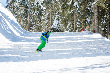 Image of man riding snowboard from snowy hill