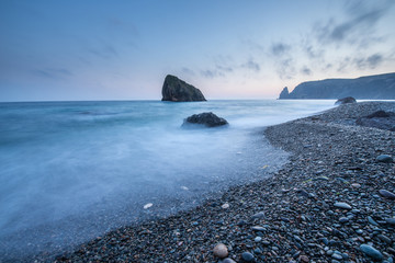 Scenic sunset on a rocky seashore on long exposure