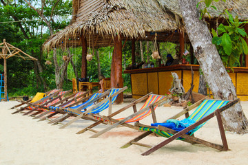 Colorful chairs on the island near an exotic bar