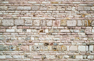 Stones and bricks mixed in a traditional wall construction of center Italy.