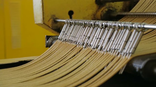 Dough for pretzels at a confectionery factory. The dough for the pretzels moves along the conveyor belt. Dough in the form of a long thread. Dough at the confectionery factory.