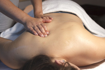 Manos de masajista sobre espalda en una sesi&oacute;n de masaje