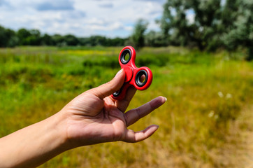 Red fidget spinner in female hand