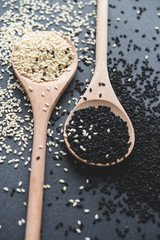 white and black sesame on wooden spoons