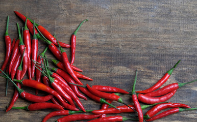 Many red peppers on a wooden background