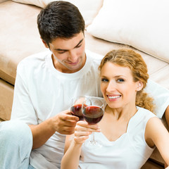 Cheerful couple with glasses of redwine