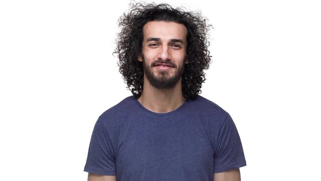 Closeup portrait of hairy muscular man 25y in casual gray t-shirt nodding and expressing approval with smile, over white background. Concept of emotions