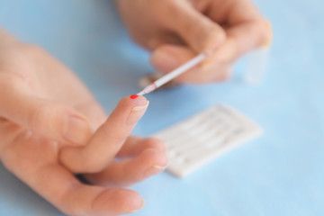 Woman taking blood sample for test, closeup