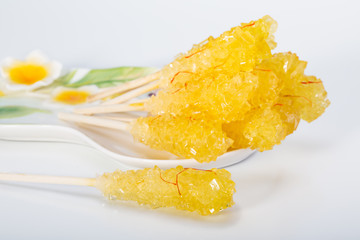 Close Up Of Saffron Rock Candy Sugar Crystal in A White Plate Isolated on White Background It Is Often Used To Be Dissolved In Tea In Iranian & Persian Cuisine