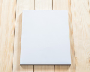 Blank book cover mockup template with page front side on white surface on wood table