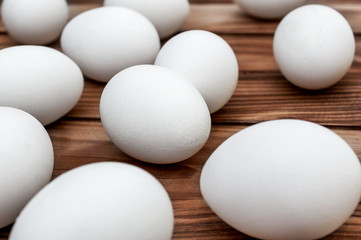 White eggs on the brown wooden table.