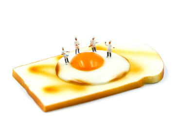 Miniature people : Chef on Toast bread with egg on white background.