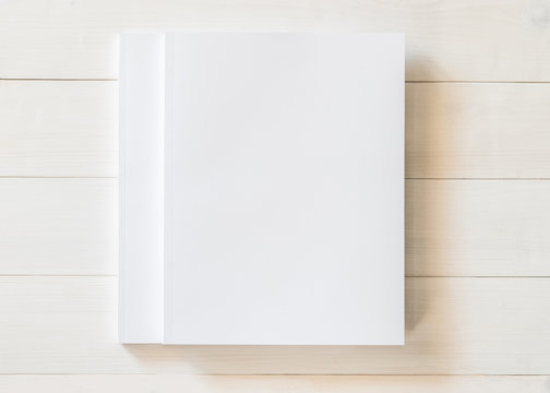 Blank book cover template with page in front side standing on white wood background flat lay.