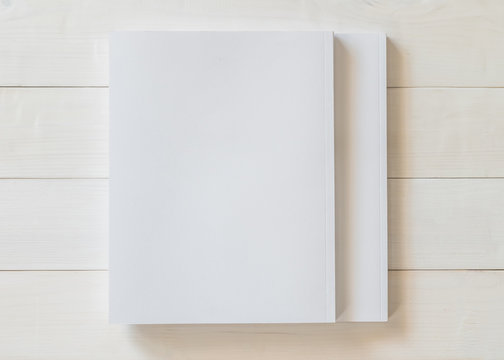 Blank book cover template with page in front side standing on white wood background flat lay.