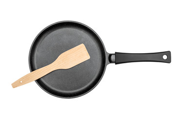 Frying pan with wooden spade on white background. Top view.