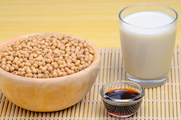 soy milk, soy sauce,soy seeds in wooden  and glass dishware