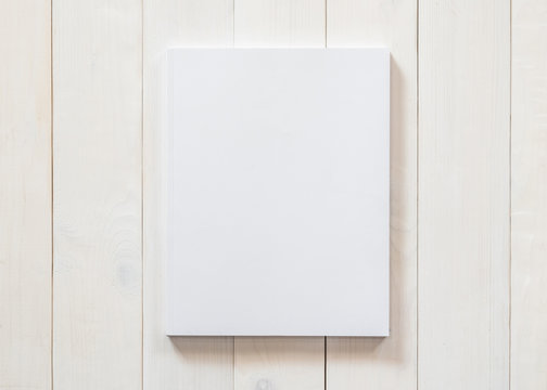 Blank A4 size book cover mockup template with page front side on white surface on wood table