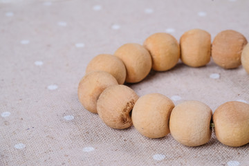 Fototapeta na wymiar macro wooden beads necklace on the brown fabric
