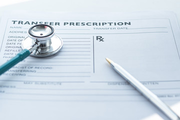 Doctor's notepad work with patient's medical health record blank paper form for prescription with stethoscope on table