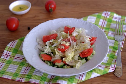Vegetable salad with tomatoes, cucumber and lettuce dressed with olive oil