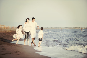 Fototapeta na wymiar happy young family have fun on beach at sunset