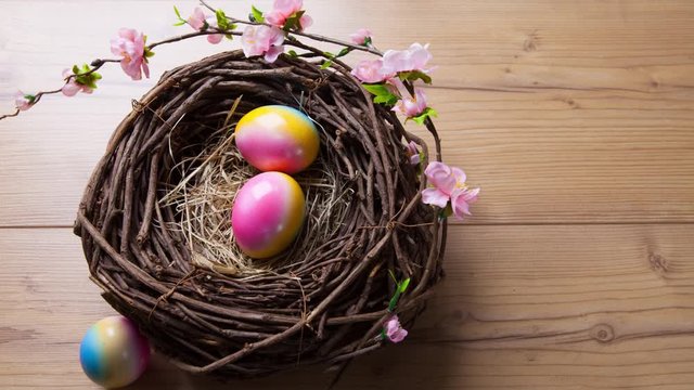 stop motion of easter eggs rolling into a easter nest