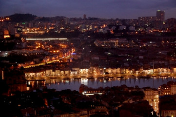 Night panoramic view of the Porto city center and the Douro river with the lights reflections in the water